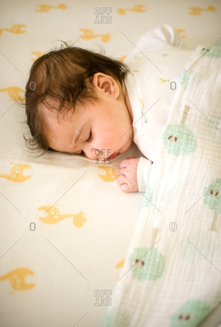 Baby sleeping under a muslin blanket