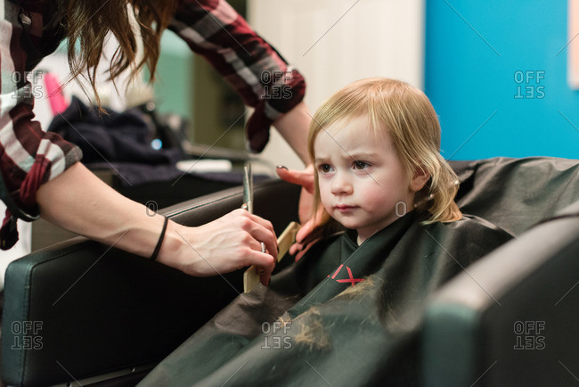 Little girl getting a haircut stock photo - OFFSET