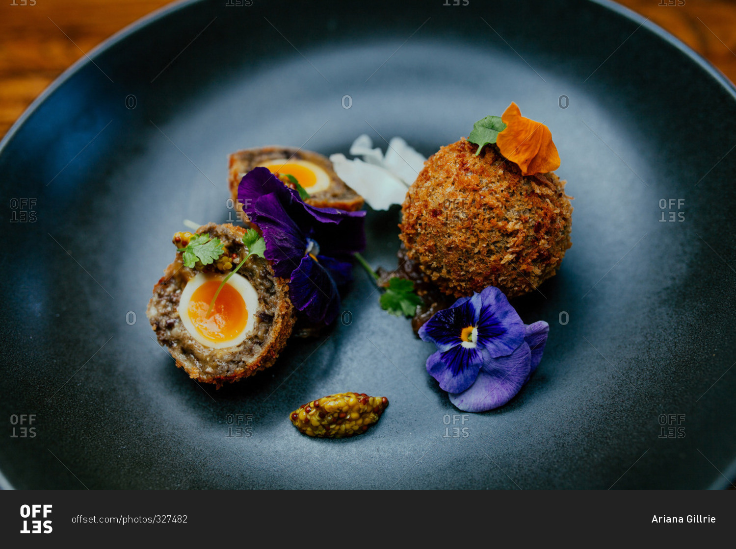 Deep fried eggs garnished with purple flowers