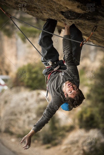 Margalef, Catalunya, Spain - February 25, 2015: Upside down professional climber Stefano Ghisolfi climbing the route of Demencia Senil