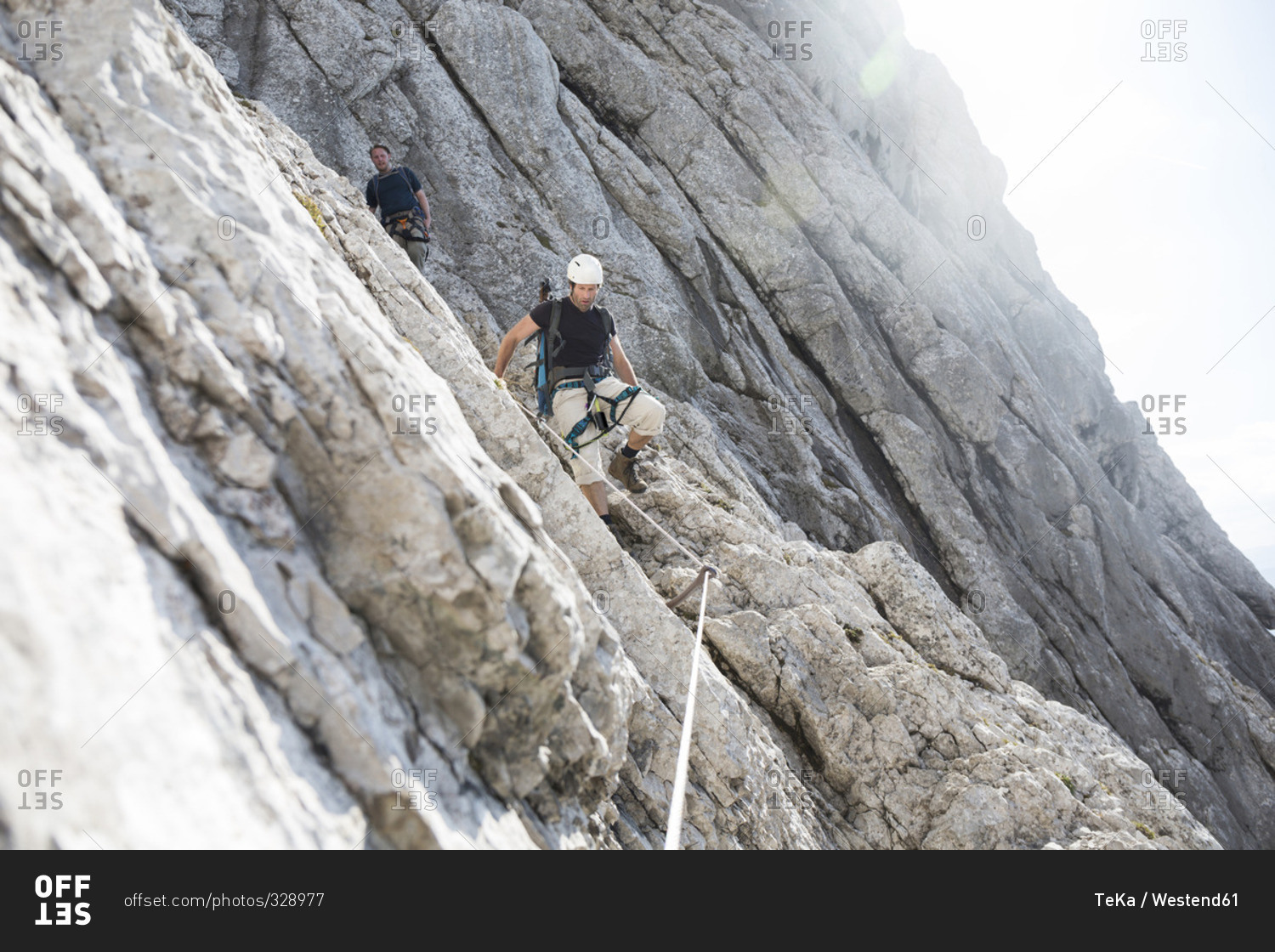 Two men climbing down a via ferrata