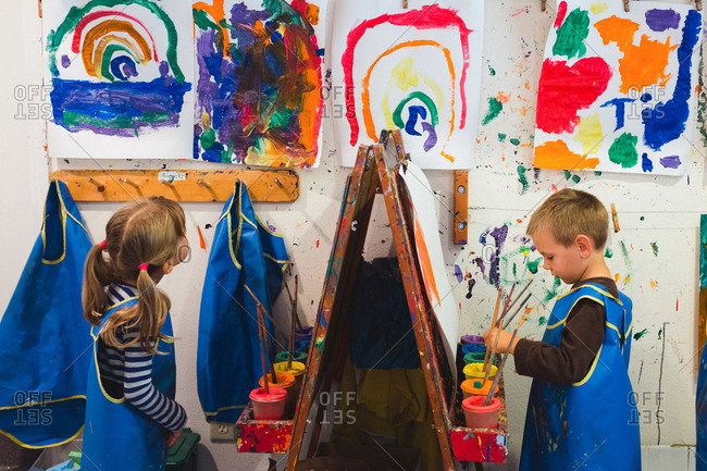 Two preschool kids painting at easels