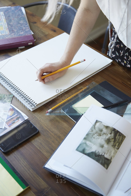 Young artist looking at images in a book for inspiration