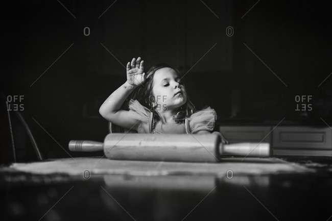 Black And White Of A Little Girl Sweeping Hair From Her Face While