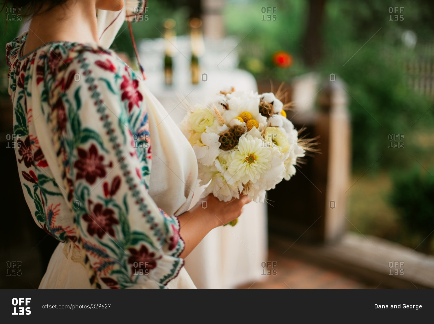 Close-up of bride in Romanian embroidered blouse holding her wedding bouquet