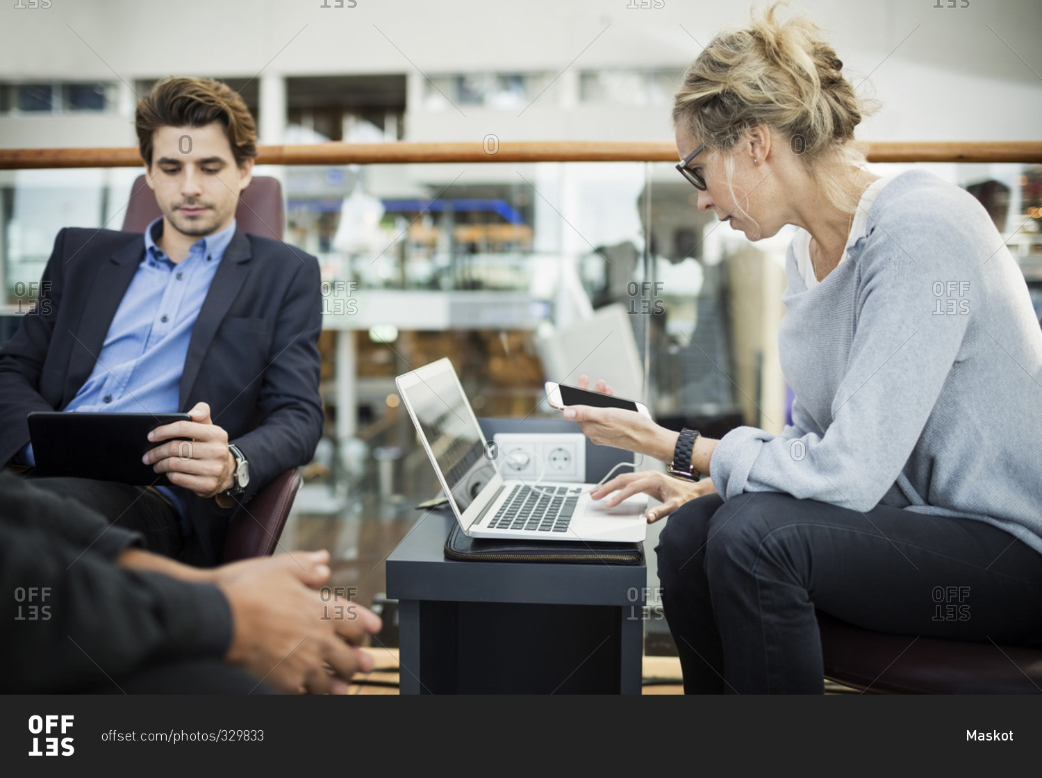Businesspeople using technologies at airport lobby