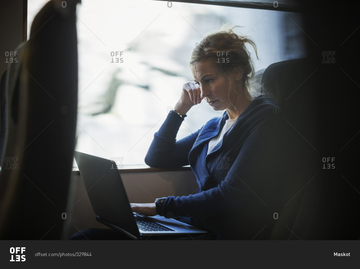 Businesswoman using laptop in train