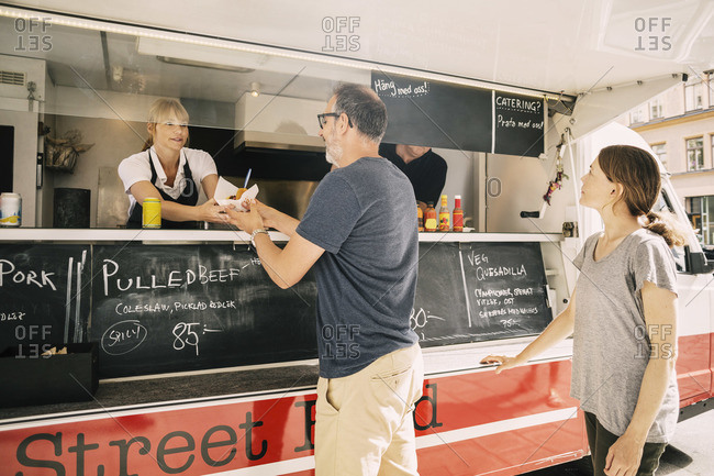 Customer buying food from vendor at food truck
