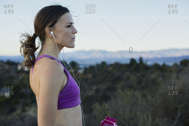 Athletic woman with earbuds and bottle