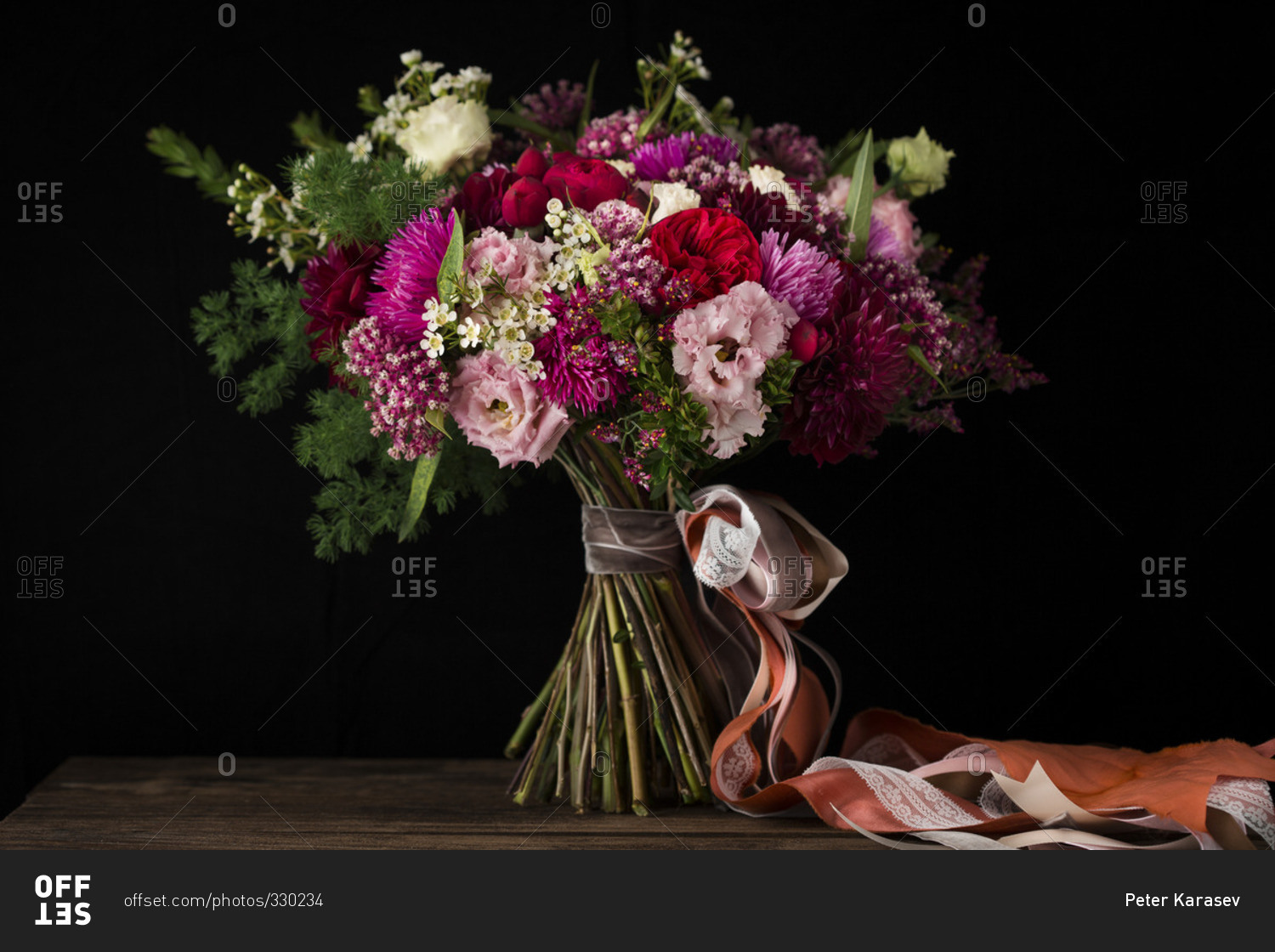 A bouquet of flowers on a table in front of a black background