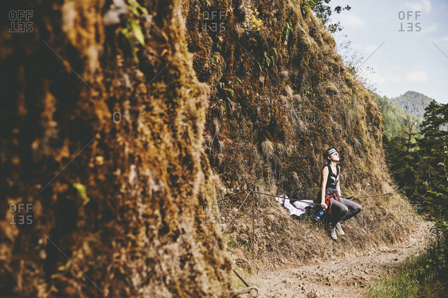 Woman resting along a narrow trail near Punchbowl Falls in Oregon