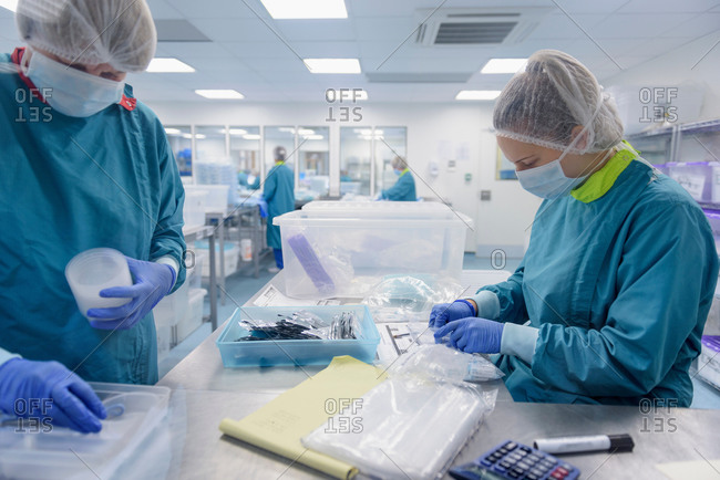 Workers packing and checking surgical instruments in clean room of surgical instruments factory