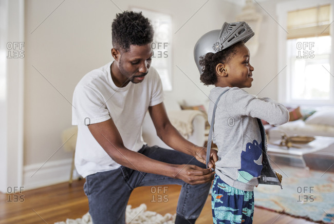 Father putting pretend armor on his son