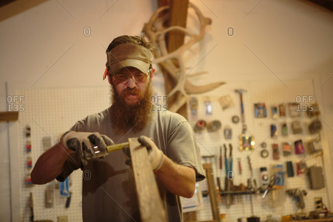 Wood artist in workshop measuring wood