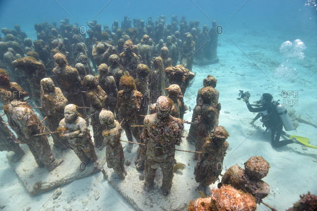 High angle view scuba diver photographing Cancun\'s underwater statues, Isla Mujeres, Quintana Roo, Mexico