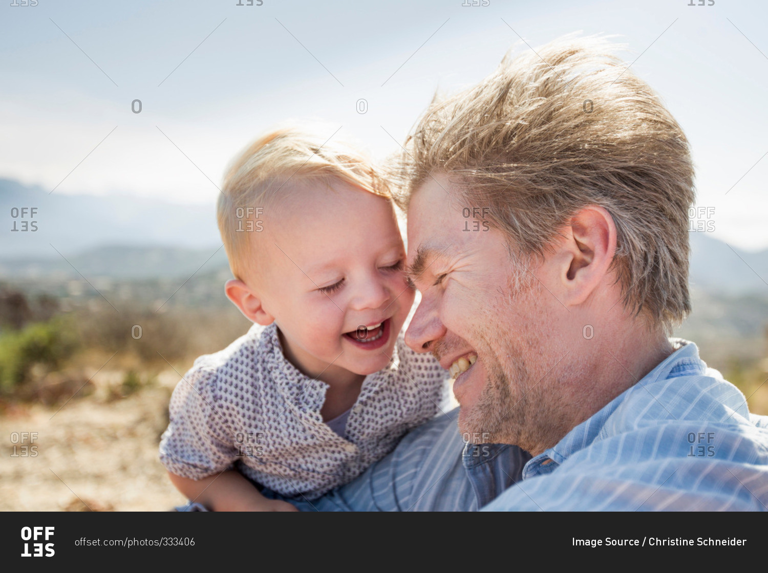 Mature man and toddler daughter laughing, Calvi, Corsica, France