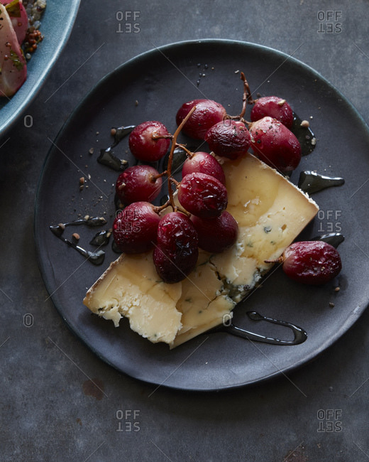A plate of roasted grapes with blue cheese