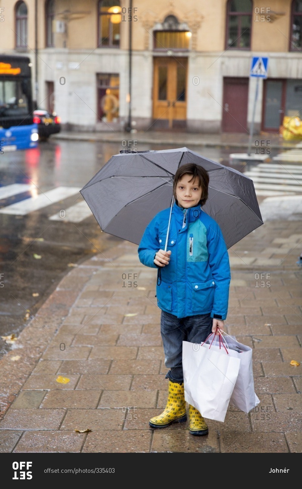 Boy at rain with paper bags