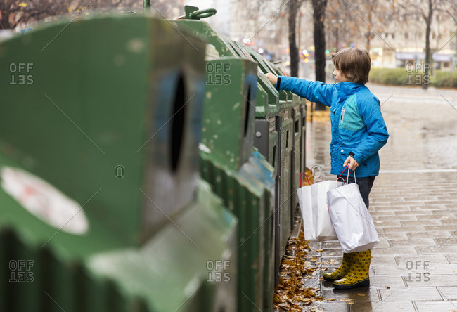 Boy putting waste into recycling bin