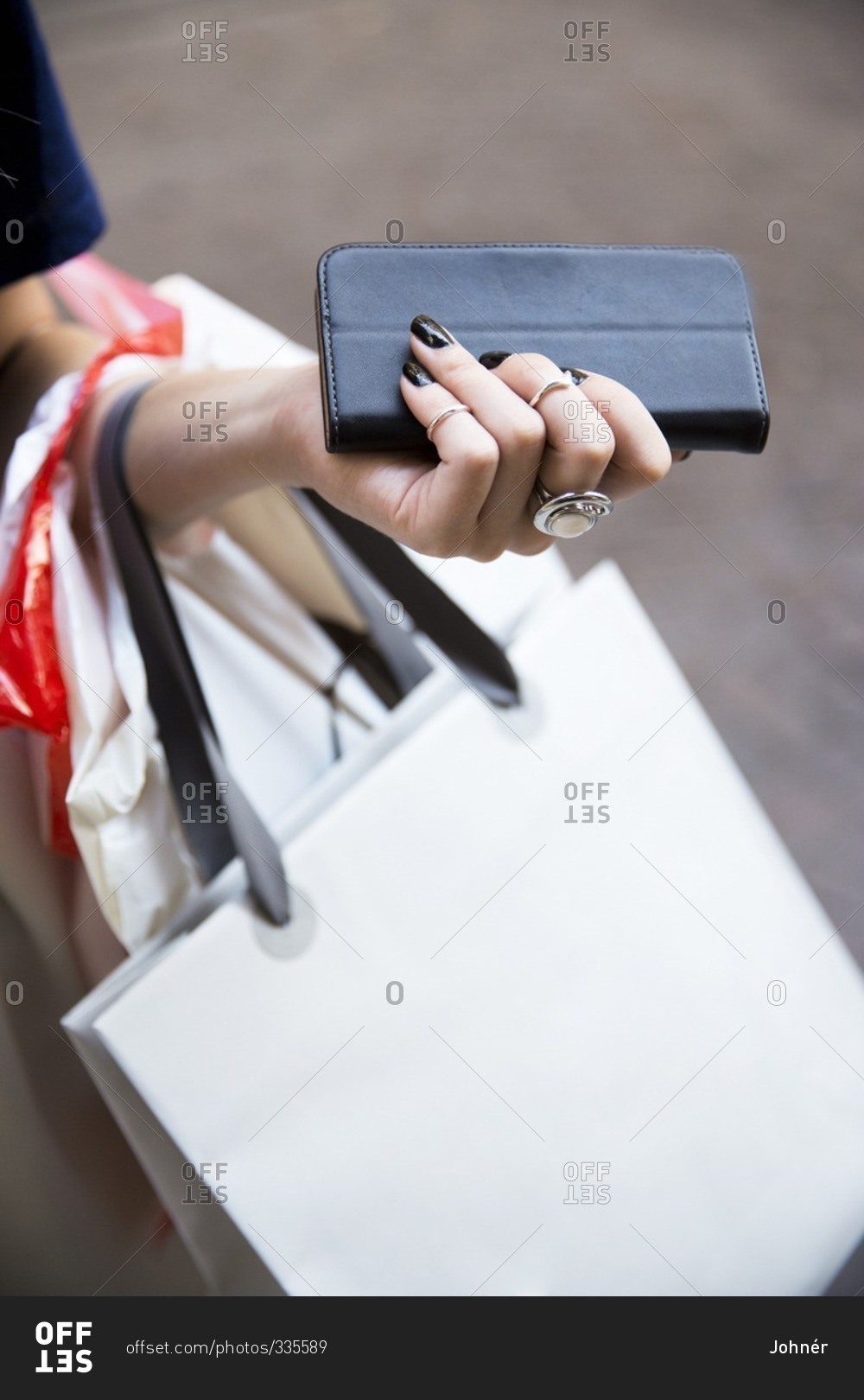 Close-up of woman with shopping bags and wallet