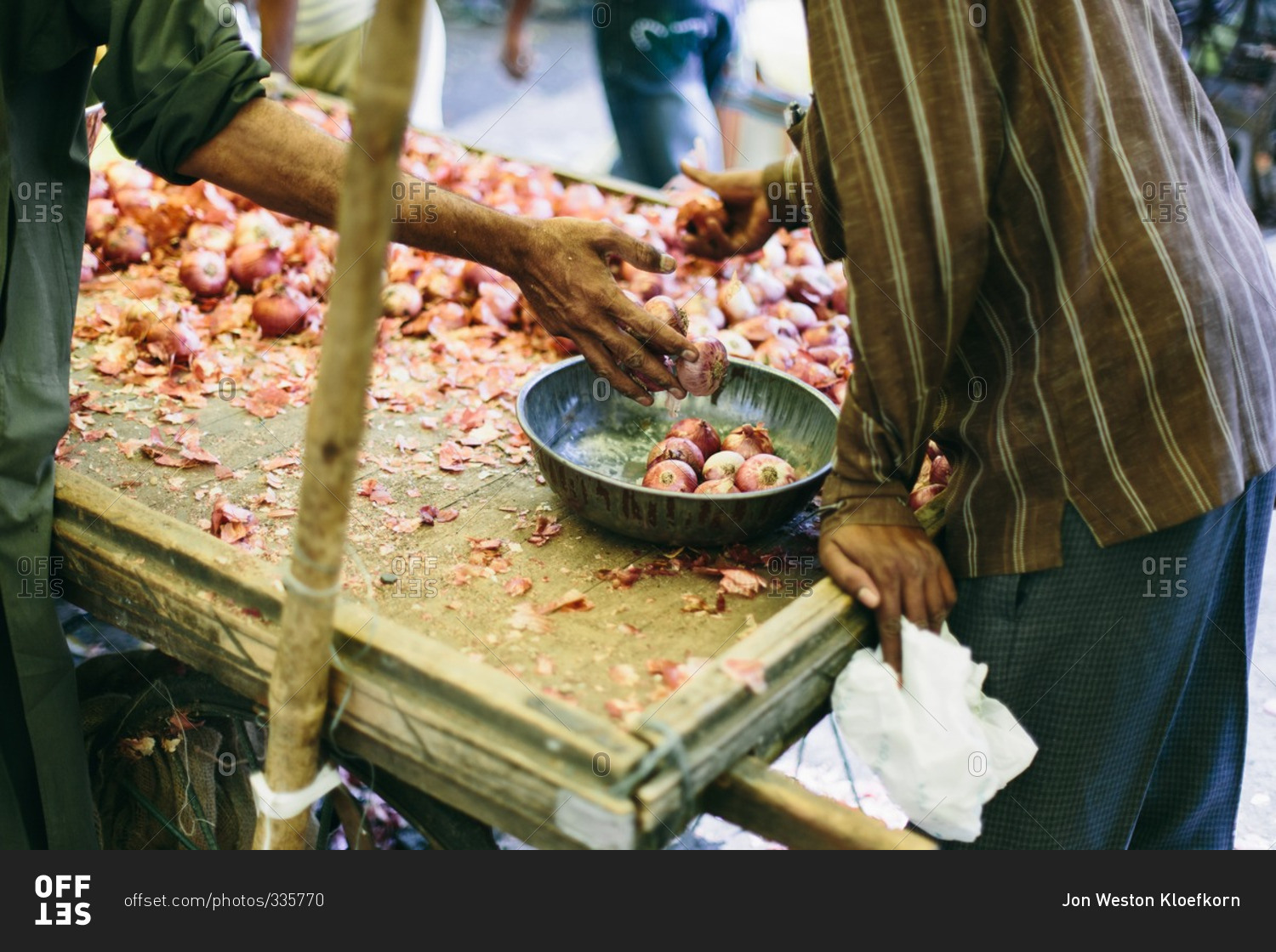 Man dropping onions into a bowl at a market in India
