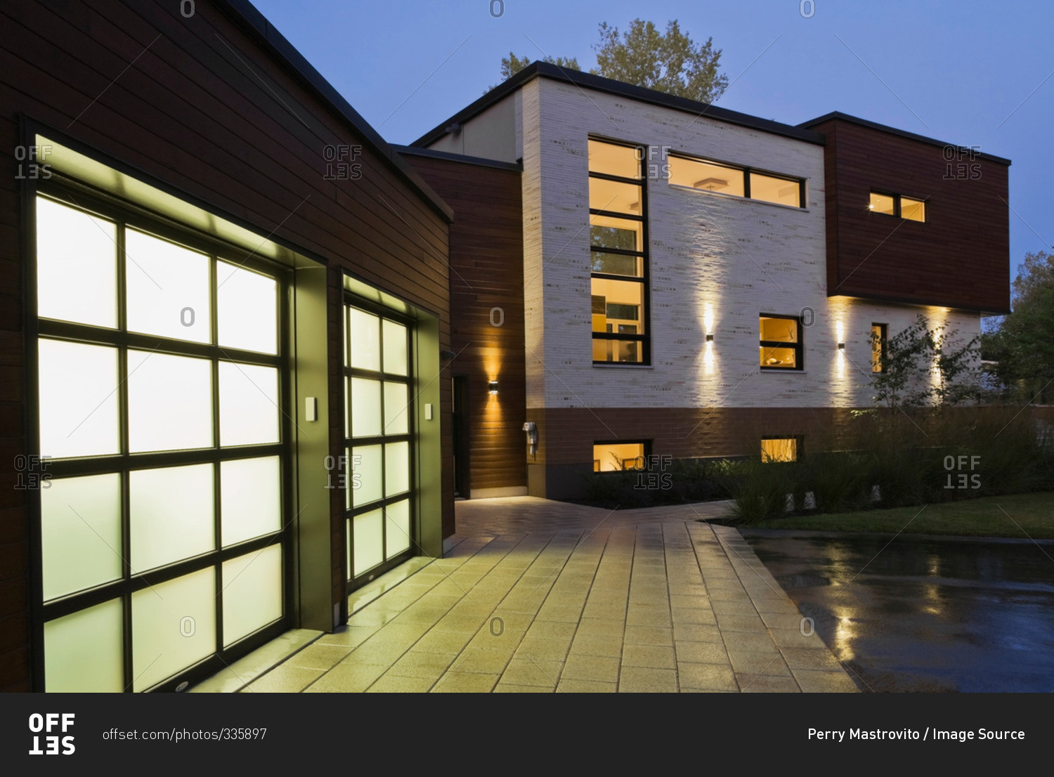 Illuminated two car garage of modern cubist style residential home at dusk, Quebec, Canada