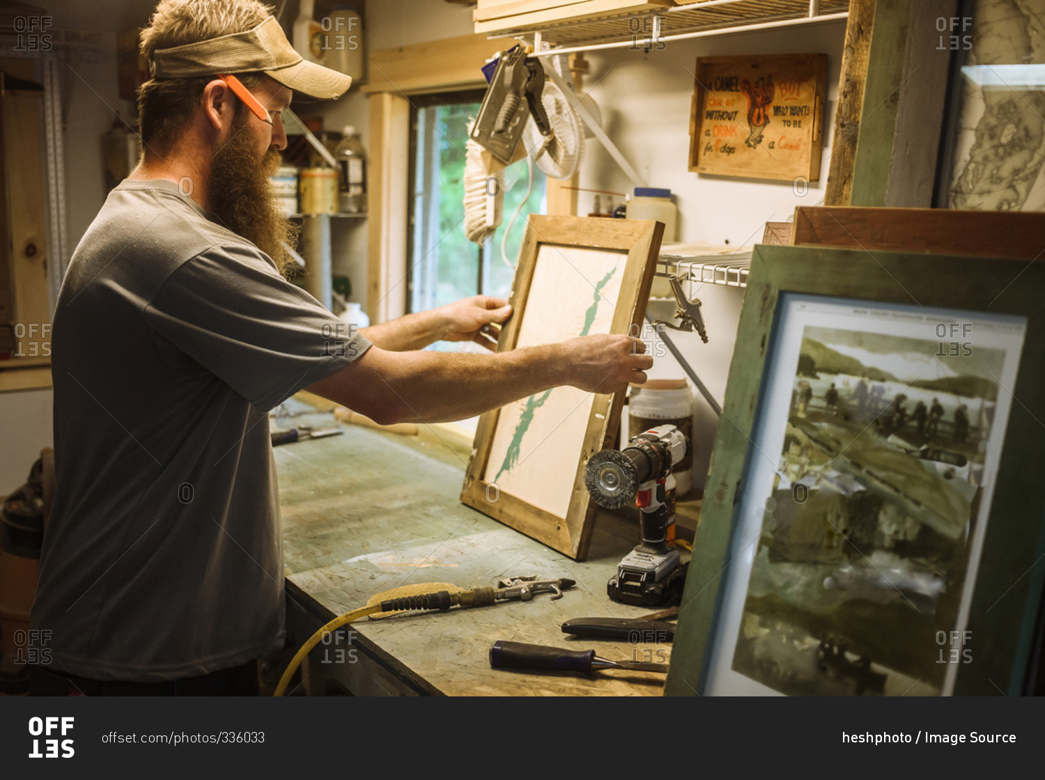 Artist working in workshop, framing artwork