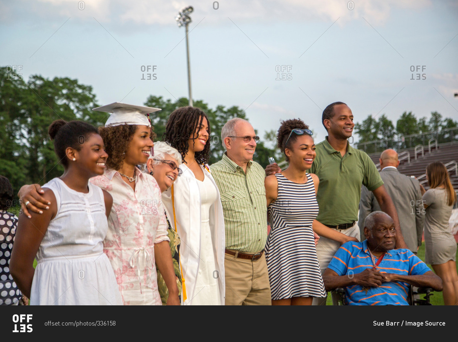 Teenage girl with large family at graduation ceremony