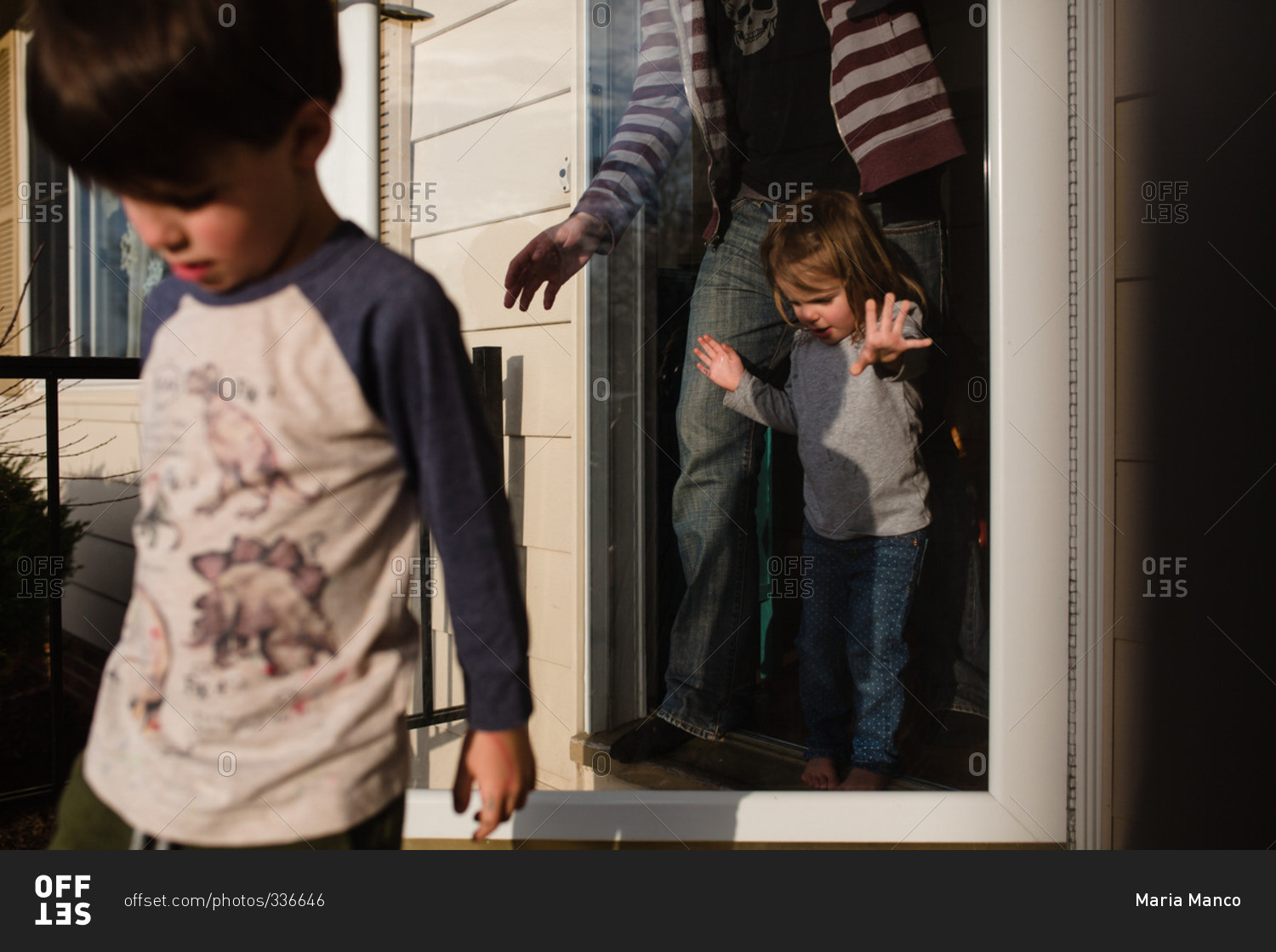 Father and young children walking out their front door stock photo OFFSET