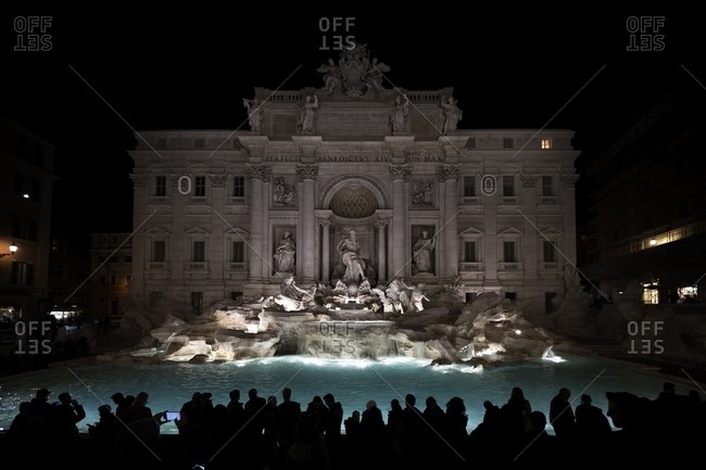 People in front of the Trevi Fountain at night