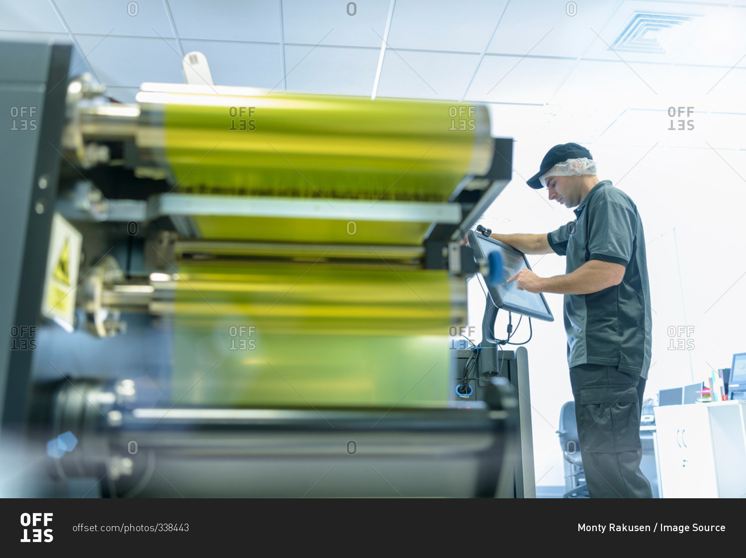 Worker with ink jet printer in food packaging printing factory