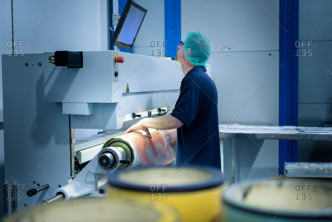 Worker preparing printing plates in food packaging printing factory