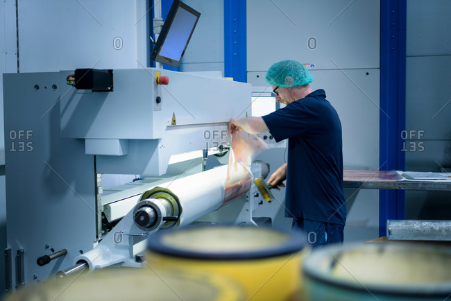 Worker prepping printing plates in food packaging printing factory