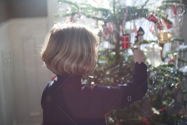 Little girl adorning a Christmas tree