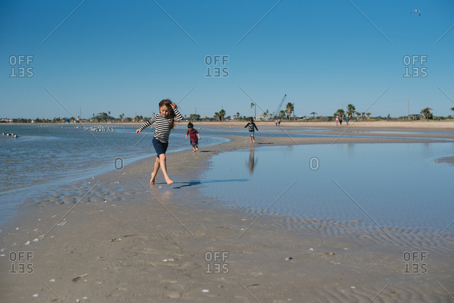 Girls walking on sandy shore