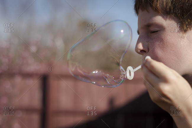 Boy blowing a soap bubble