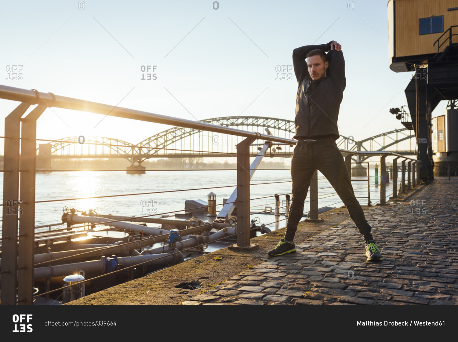 Germany, Cologne, Young man worming up for workout