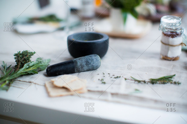Mortar and pestle with fresh herbs on dining table