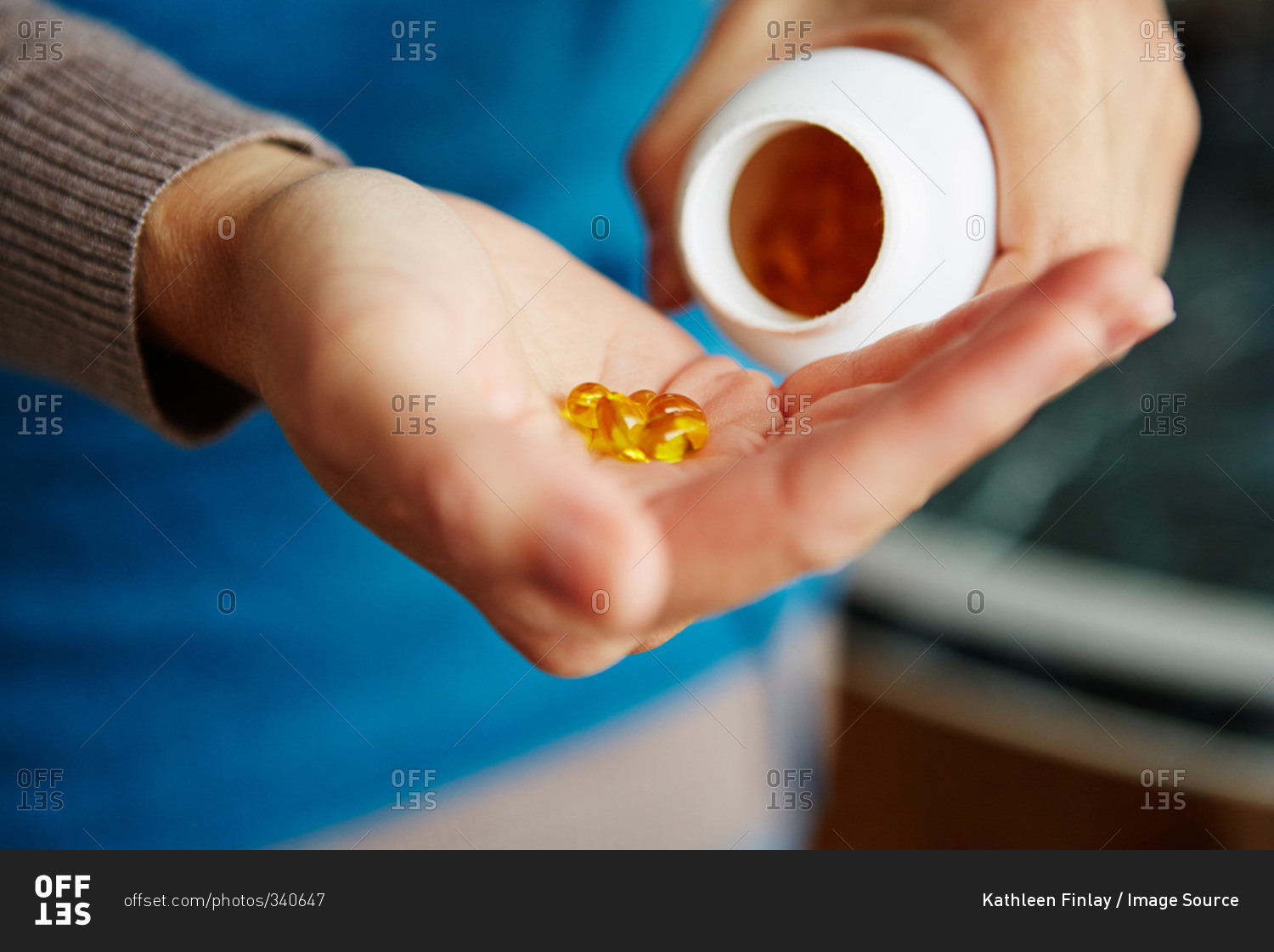 Young woman taking medication from bottle, close-up