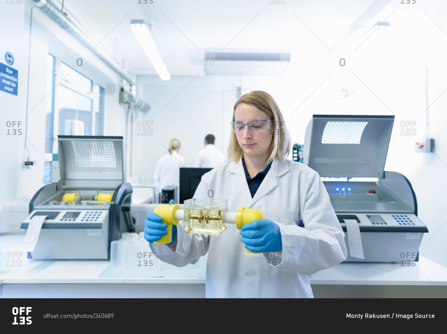 Female scientist with oil sample in testing facility