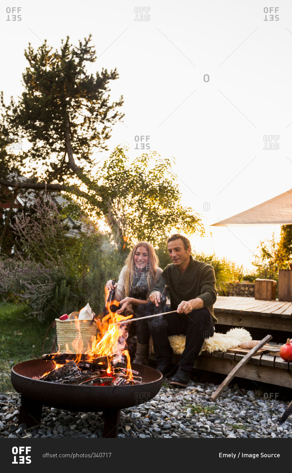 Couple sitting by fire pit in garden
