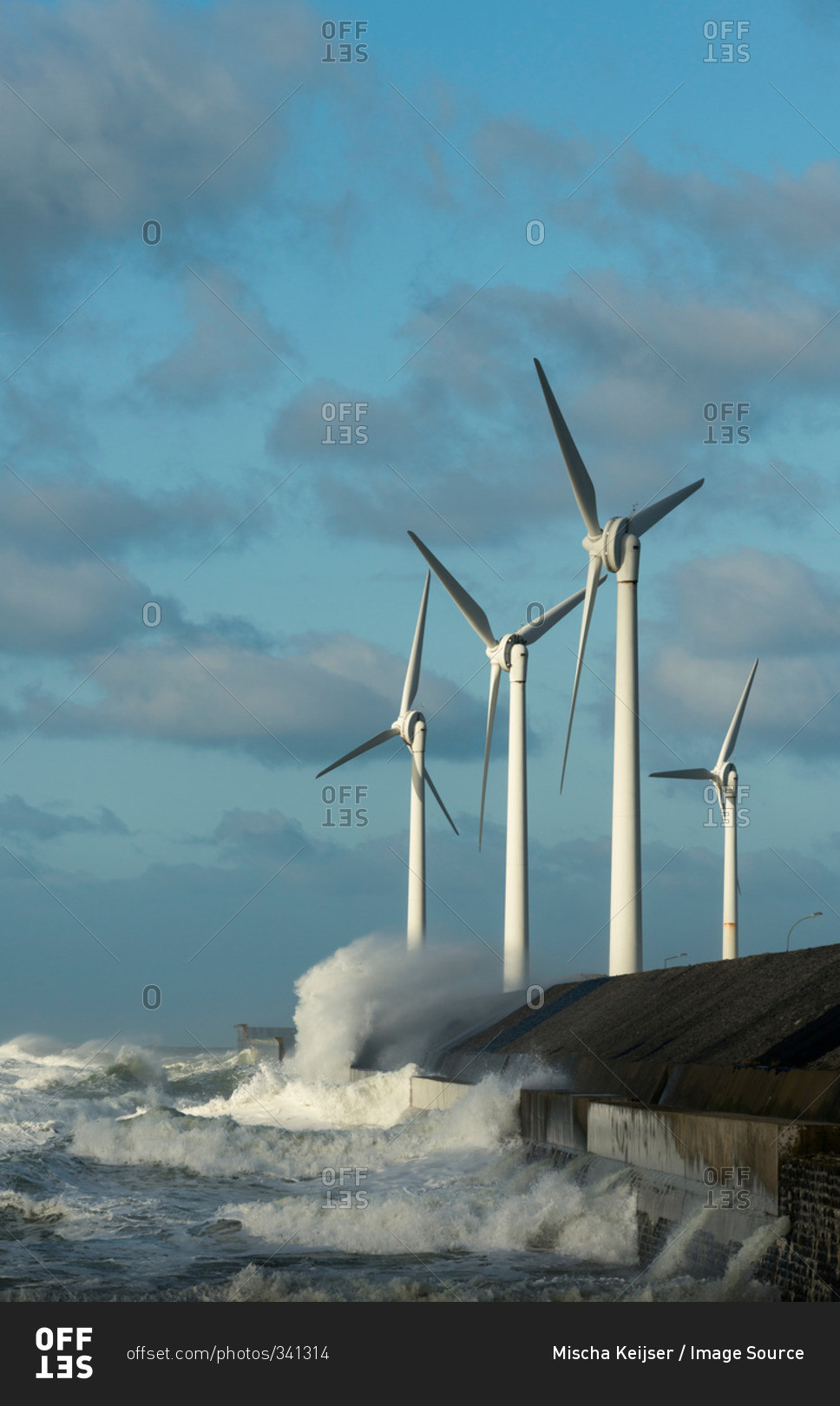 Stormy ocean waves splashing wind turbines and harbor wall, Boulogne-Sur-Mer, Pas de Calais, France