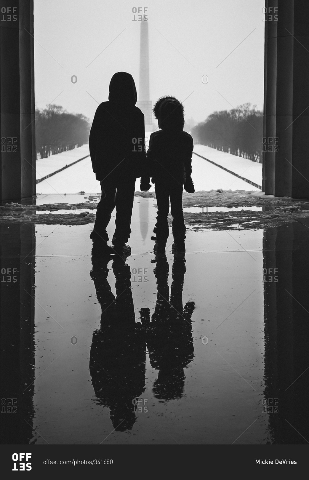 Two young children silhouetted before the Washington Monument