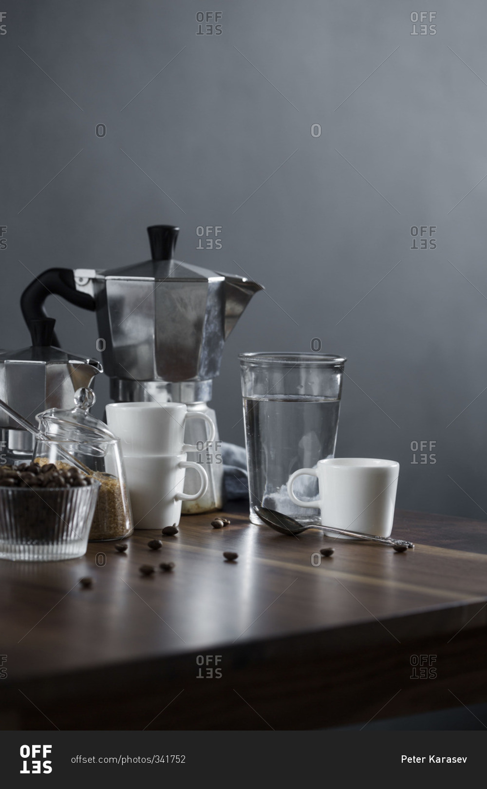 Moka coffee pot and coffee cups on a wood table with raw sugar and coffee beans