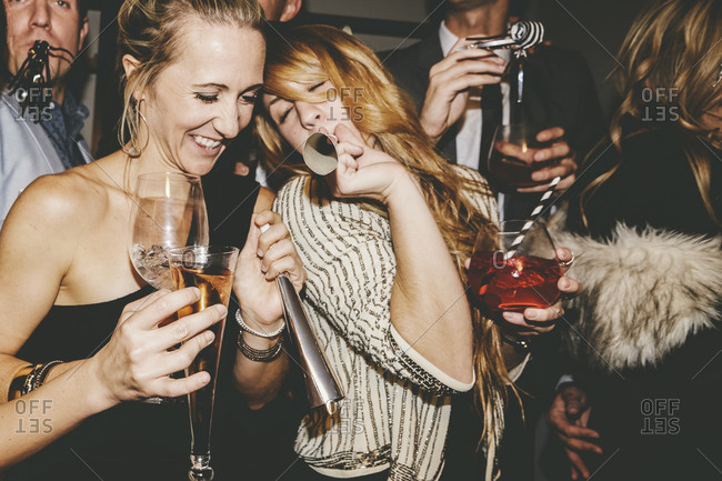 Friends blowing noisemakers at a party