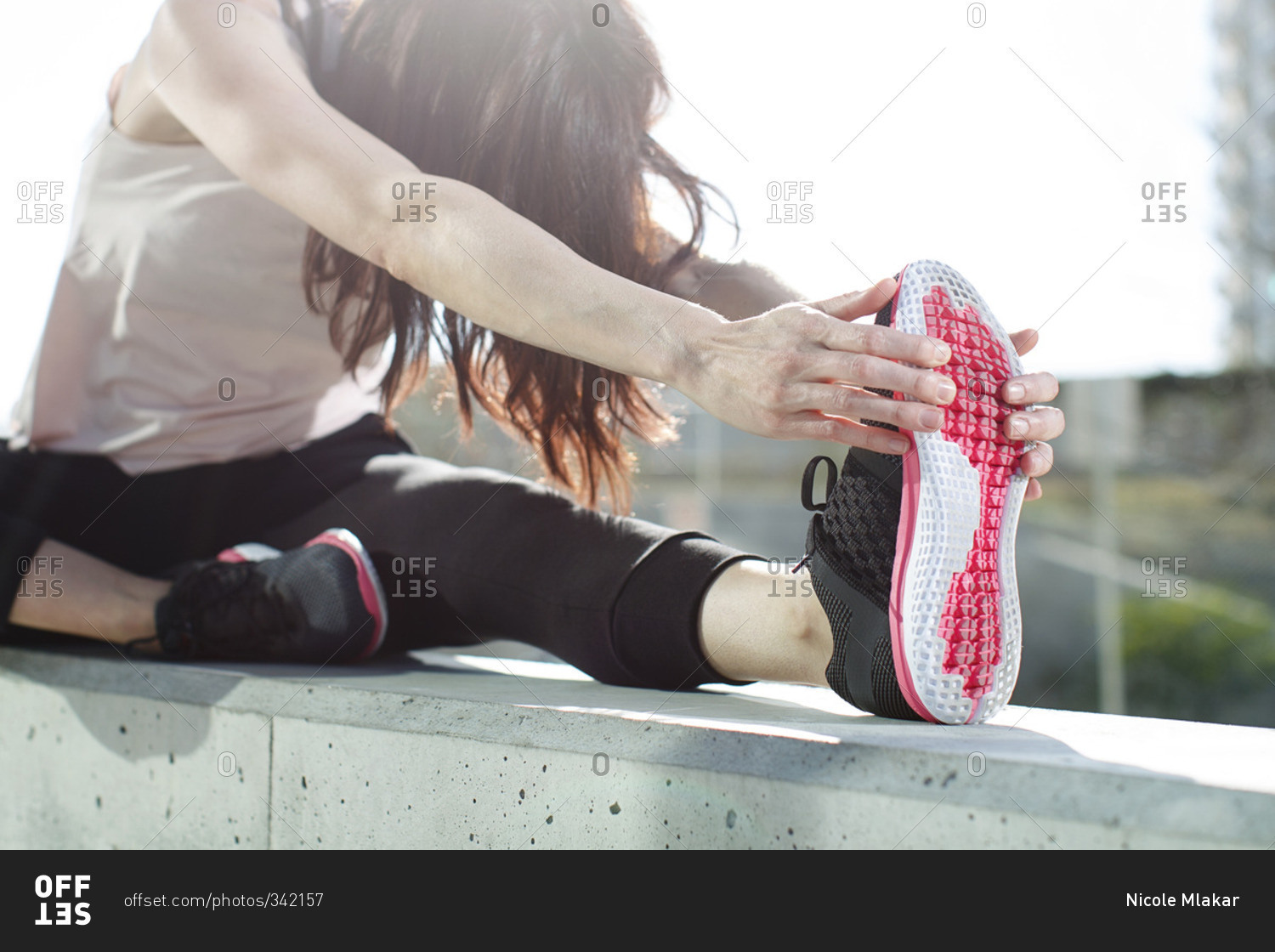 Woman wearing running shoes stretching in preparation for exercise