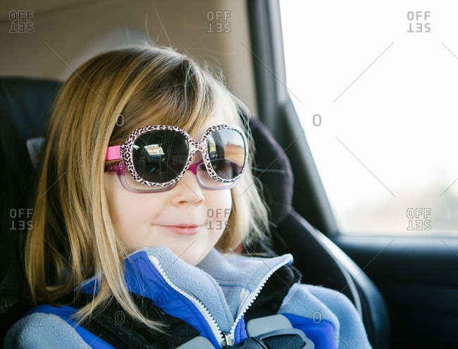 Little girl in car seat wearing sunglasses over her eyeglasses stock ... Little girl in car seat wearing sunglasses over her eyeglasses stock ...