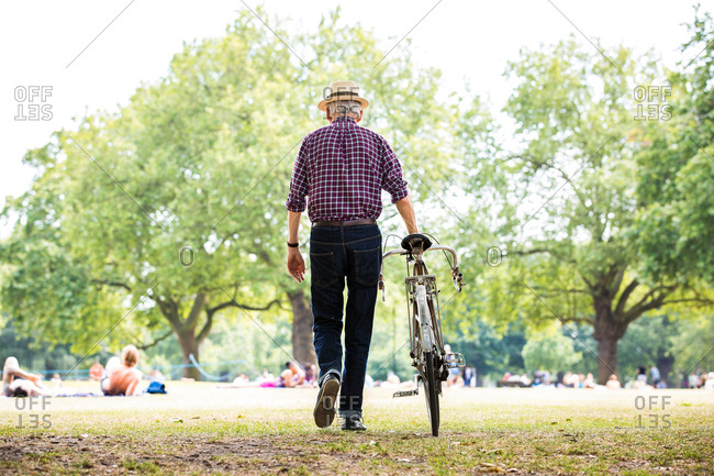 Senior man with bicycle in park, Hackney, London