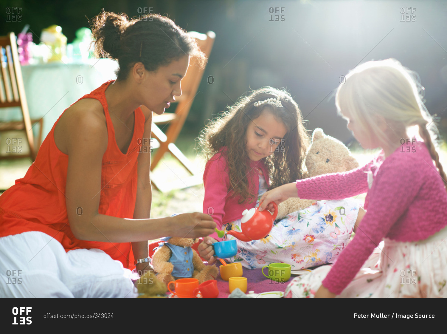 Mother and two girls playing picnics at garden birthday party