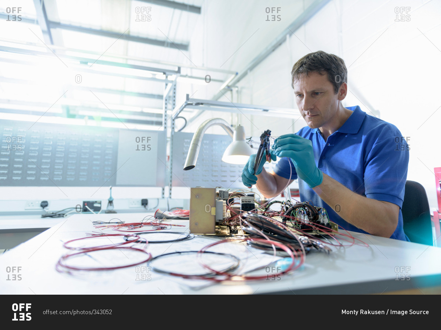 Worker putting together electronics in electronics factory